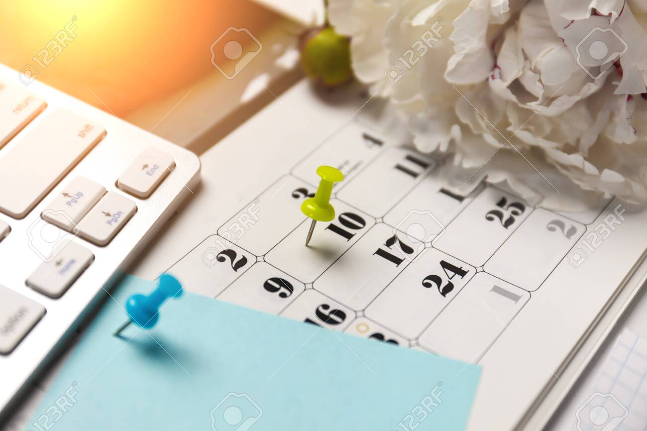 149889611-a-blue-color-pin-on-calendar,-keyboard,-blank-blue-paper-and-pencil